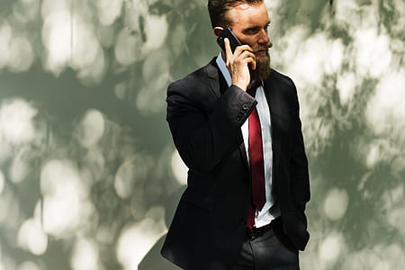 man in black blazer near white wall thumbnail