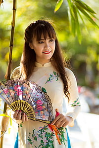 woman holding folding hand fan thumbnail