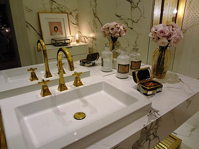 gold-colored steel faucet with white ceramic sink thumbnail