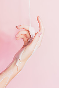 human hand with white liquid thumbnail
