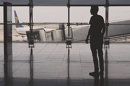 silhouette of man standing inside airport thumbnail