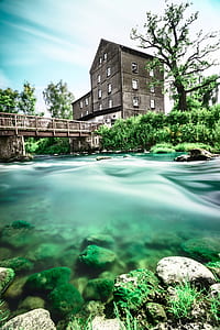 black 4-story house near concrete bridge and river thumbnail