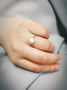 person wearing white jeweled gold-colored ring thumbnail