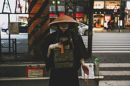 man wearing brown hat standing near road thumbnail