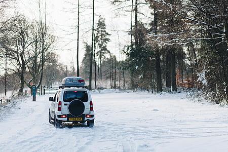 white vehicle passes on snow road thumbnail