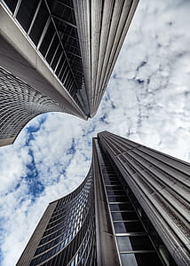 low angle photography of glass curtain building under blue sky and white clouds during daytime thumbnail