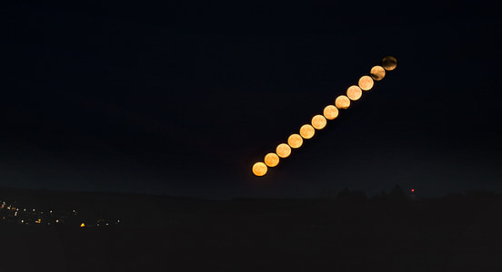 timelapse photography of orange moon at nighttime thumbnail