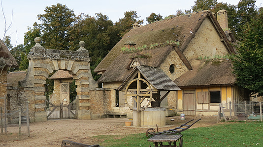 brown wooden house near white and brown well thumbnail
