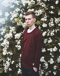man standing in front of white flowers thumbnail