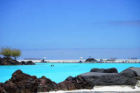 black rock beside blue body of water\ thumbnail