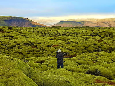 person in black hoodie standing on mountains thumbnail