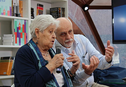 man and woman sitting on bench while holding microphone thumbnail