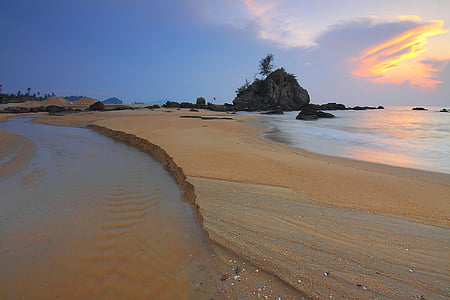 water flowing in brown sand during golden hour thumbnail