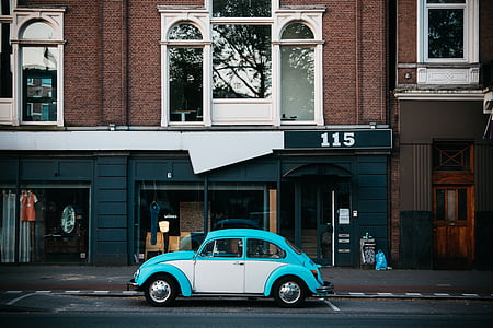 blue and white Volkswagen Beetle parked on the street thumbnail
