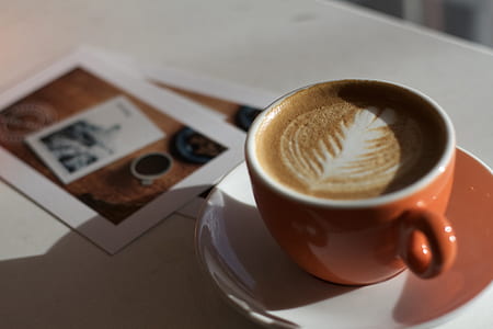 coffee art on orange teacup thumbnail