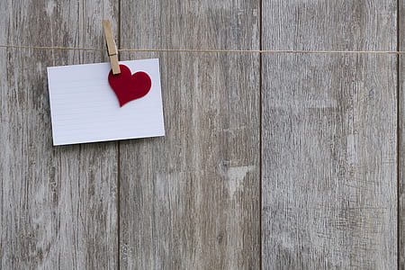 white printer paper and red paper heart cutout clipped by clothes pin photograph thumbnail