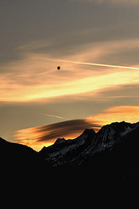 bird soaring near mountain during golden hour thumbnail