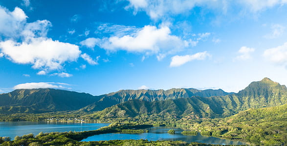 Green Forested Mountain Range Under Blue Sky With Clouds thumbnail