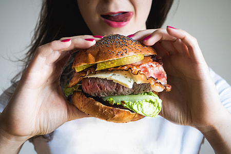 Young lady holding huge burger thumbnail