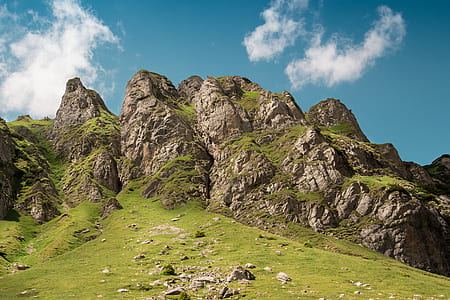 green rocky mountain under blue and white sky at daytime thumbnail