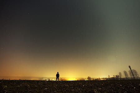 person standing under gray starry sky thumbnail
