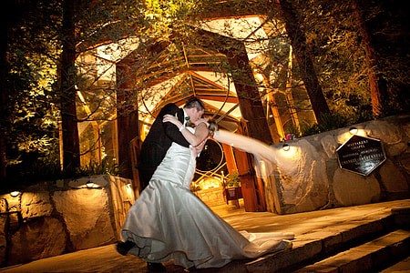 groom kissing his bride near stairs thumbnail