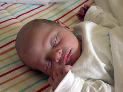 baby laying down on bed thumbnail