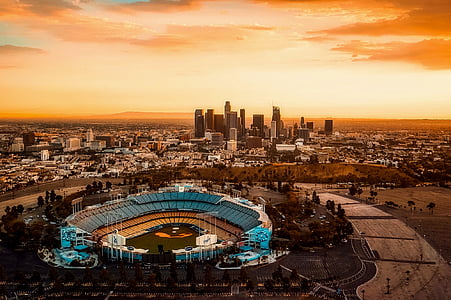 grey and black baseball stadium overlooking skyscraper under sunset sky thumbnail