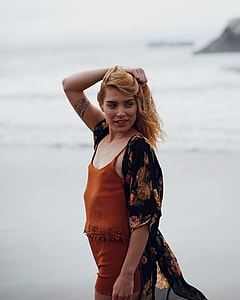 woman wearing orange spaghetti strap romper shorts thumbnail