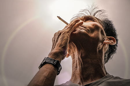man holding smoke while looking upward thumbnail