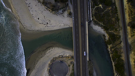 aerial view of concrete road near body of water thumbnail