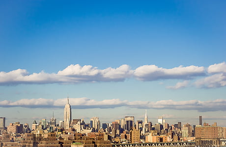 high rise concrete buildings under white clouds at daytime thumbnail
