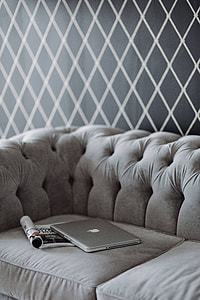 Elegant grey sofa with a laptop, an iPhone and a magazine thumbnail