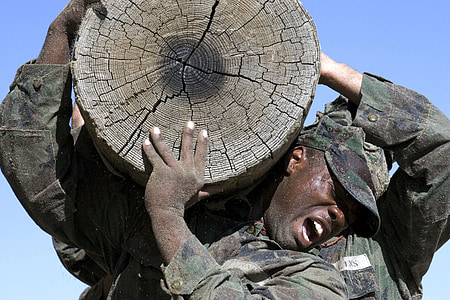 man in soldier uniform carrying wood slab thumbnail