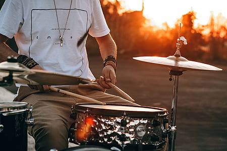 photography of man playing drum during golden hour thumbnail