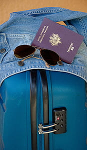 aviator sunglasses beside passport book on denim jacket thumbnail