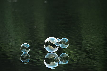 four bubbles near body of water thumbnail
