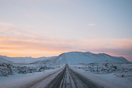 empty road between snow covered fields thumbnail