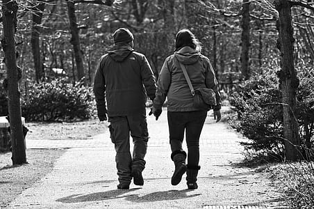 man and woman walking on pathway grayscale photo thumbnail