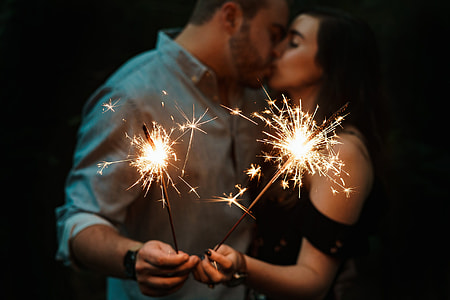 man and woman kissing while holding spark firecrakers thumbnail