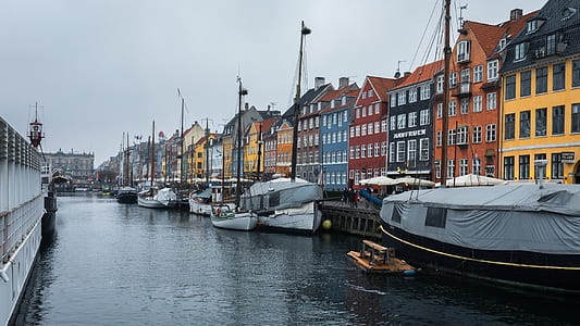 boat docks near multicolored concrete buildings during daytime thumbnail
