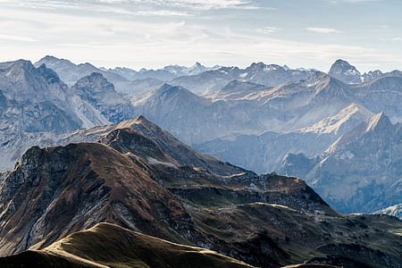 aerial photography of mountain under blue sky and white clouds view during daytime thumbnail
