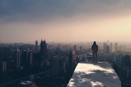 person stand on clif rock under blue skies during daytime thumbnail
