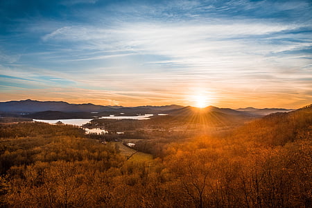brown trees near lake and mountain during sunrise thumbnail