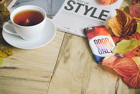 white ceramic teacup beside iPhone and red leaves thumbnail