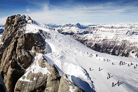 Landscape shot of people skiing on the snow slopes of the Dolomite mountains in Italy thumbnail