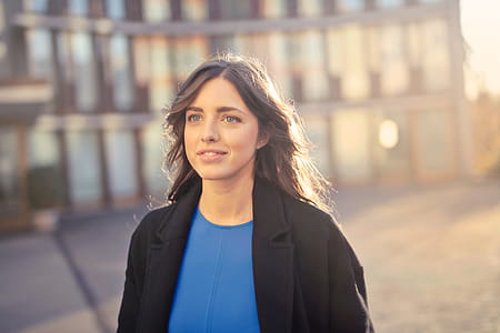Selective Focus On Woman In Black Blazer And Blue Shirt Walking On Street thumbnail