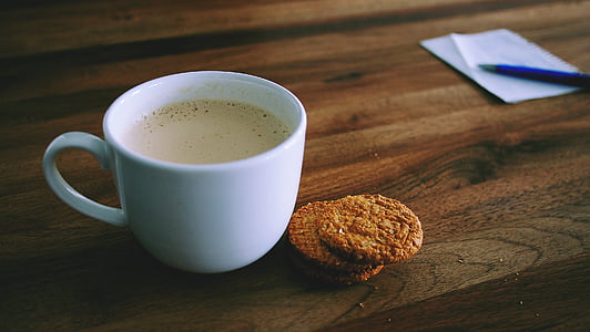 cookies beside white ceramic teacup filled with coffee thumbnail