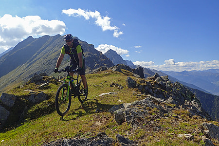 man riding bicycle on hilltop during daytime thumbnail