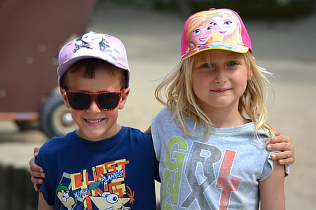 two smiling boy and girl holding there shoulders during daytime thumbnail